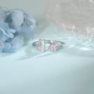 Détail d'une bague ouverte en argent avec chat en émail rose et motif fleur de cerisier.