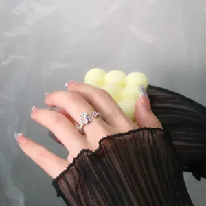 Gros plan d'une bague ouverte argentée mignonne avec fleur de cerisier et chat rose