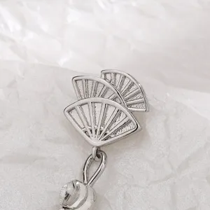 Detailed close-up of a silver Chinese style fan-shaped earring with textured finish