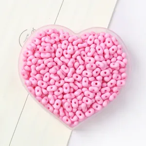 Macro detail of pink peanut-shaped candy color acrylic beads for DIY jewelry making