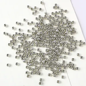 Primo piano di perline a botte in acrilico argento 3x4mm per creazione gioielli fai-da-te.