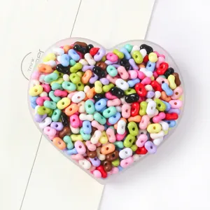 Close-up detail of colorful peanut-shaped candy color beads in a heart-shaped tray