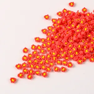 Primo piano di piccoli ciondoli a forma di rosa in resina rossa e gialla per nail art DIY