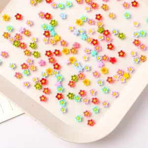 Petits breloques d'ongles en fleurs de résine 6mm et cabochons de coque de téléphone vue en détail.