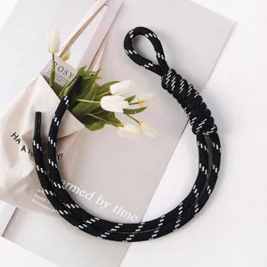 Close-up detail of a hand-woven black and white patterned rope strap for bags or keys.