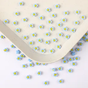 Vue détaillée de petits cabochons de fleurs en résine bleue pour nail art et loisirs créatifs.