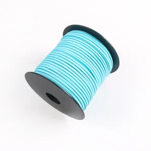 Close-up detail of light blue faux suede cord wound on a black spool, soft texture.
