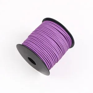 Close-up of vibrant purple faux suede cord wrapped on black spool, ideal for DIY crafts.