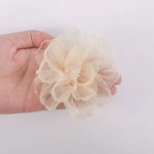 Close up view of the beige sheer chiffon flower with layered petals and burnt edge.
