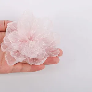 Close up of pink chiffon flower accessory, delicate burnt edge handmade 3d floral part.