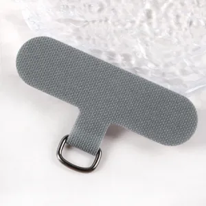 Grey fabric phone lanyard tether tab with metal D-ring, universal phone case patch gasket accessory.