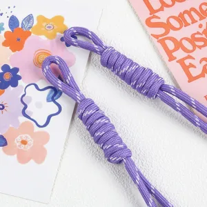 Detail shot of purple braided nylon rope lanyard charms on a decorative background