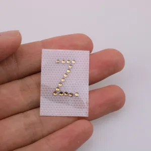 Close-up detail of letter Z rhinestone hotfix patch, sparkling DIY clothing accessory.