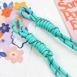 Detail view of turquoise braided nylon rope charm with black spiral accents for bags