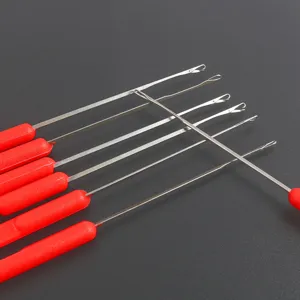 Closeup of latch hooks with red plastic handles and metal needles for beading crafts.