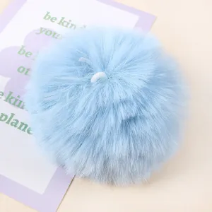 Close-up detail of light blue faux fur pom pom hanging pendant for DIY craft handmade accessories.