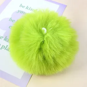Bright green faux fur pom pom detail shot, soft fluffy DIY craft accessory material.