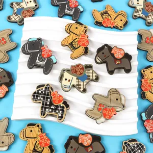 Detailed view of wooden horse charms with various patterns for DIY keychain accessories.