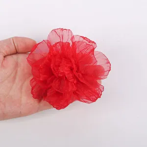 Detailed close-up of a red handmade chiffon fabric flower showing exquisite burnt-edge texture.