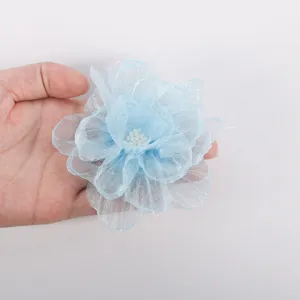 Handmade light blue chiffon fabric flower detail, perfect for DIY hair accessories and clothing.