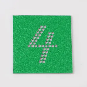 Dettaglio modello strass DIY, foglio quadrato verde con motivo a numero quattro perforato.