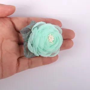 Close-up detail van mintgroene organza stoffen bloem voor DIY haarspelden en ambachten.