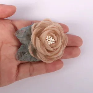 Gedetailleerd overzicht van handgemaakte organza stoffen bloem, ideaal voor DIY broches en haarspelden.