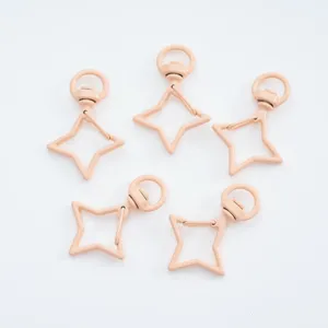 Vue détaillée de cinq mousquetons pivotants en métal rose nude en forme d'étoile