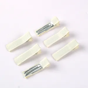 Vue rapprochée de pinces à cheveux carrées en tissu crème pour accessoires de cheveux DIY.