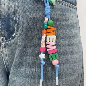 Detailed view of colorful acrylic letter beads spelling MEME on a DIY keychain charm