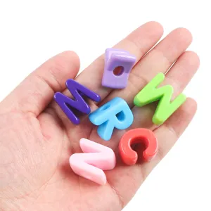 Close-up of colorful acrylic alphabet beads held in hand for DIY jewelry making.