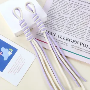 Detailed view of hand-woven purple and white nylon rope bag charms with tassel ends
