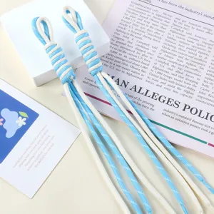 Close-up of sky blue and white braided nylon rope pendants for DIY bag charms