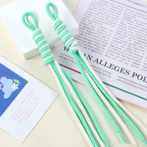 Detail of two-tone braided nylon rope bag charms in mint and cream white.