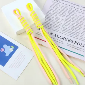 Detail of handmade bicolor nylon braided rope charm in neon yellow and pink.
