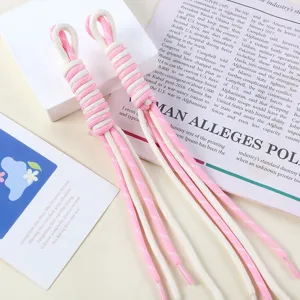 Close-up of pink and white handmade braided nylon rope bag charm with tassel detail