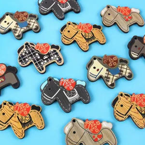 Colorful wooden horse charms for DIY jewelry and keychain pendants on blue background
