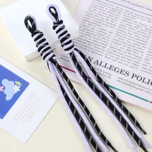 Close-up view of two bicolor purple and black braided nylon rope bag charms for DIY accessories