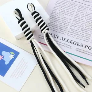 Detailed macro view of black and white braided nylon rope handmade bag charm pendant