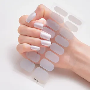 Vista detallada de pegatinas para uñas de color blanco perla metálico aplicadas en uñas.