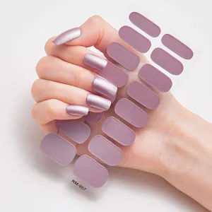 Detalle de las pegatinas de uñas color lila metalizado aplicadas en las uñas.
