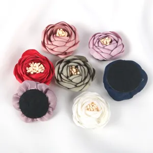 Détails de fleurs de rose en tissu 3D montrant diverses couleurs et support en feutre.