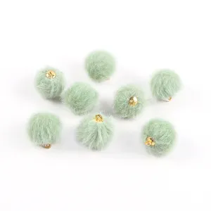 Dettaglio di ciondoli a pompon in finta pelliccia verde menta da 17mm per gioielli fai-da-te.