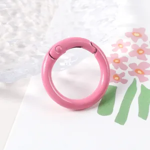 Primer plano de anillo de resorte de metal rosa con acabado de pintura, ideal para joyería DIY.