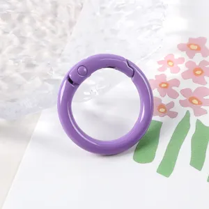 Vista detallada del anillo de resorte de metal morado, accesorio versátil para manualidades.