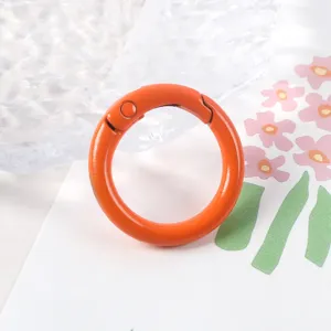 Primer plano detallado de un anillo de resorte de metal naranja brillante para joyería DIY.