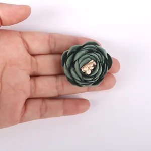 Fleur de rose en tissu 3D vert foncé tenue en main pour l'échelle, détail accessoire DIY