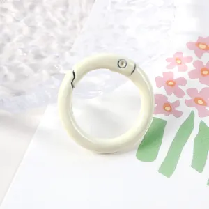 Primer plano detallado de un anillo de resorte de metal beige para manualidades y bolsos.