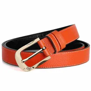 Detalle en primer plano de elegante cinturón de cuero naranja con hebilla dorada.