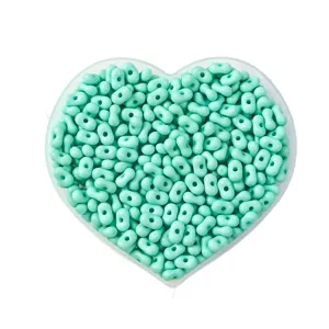 Mint green peanut-shaped seed beads for DIY jewelry making in a heart-shaped tray